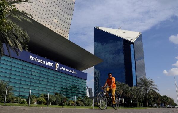 : A man rides a bicycle past Emirates NBD head office in Dubai, UAE January 30, 2018. REUTERS/Satish Kumar - RC1F060F2B60/File Photo